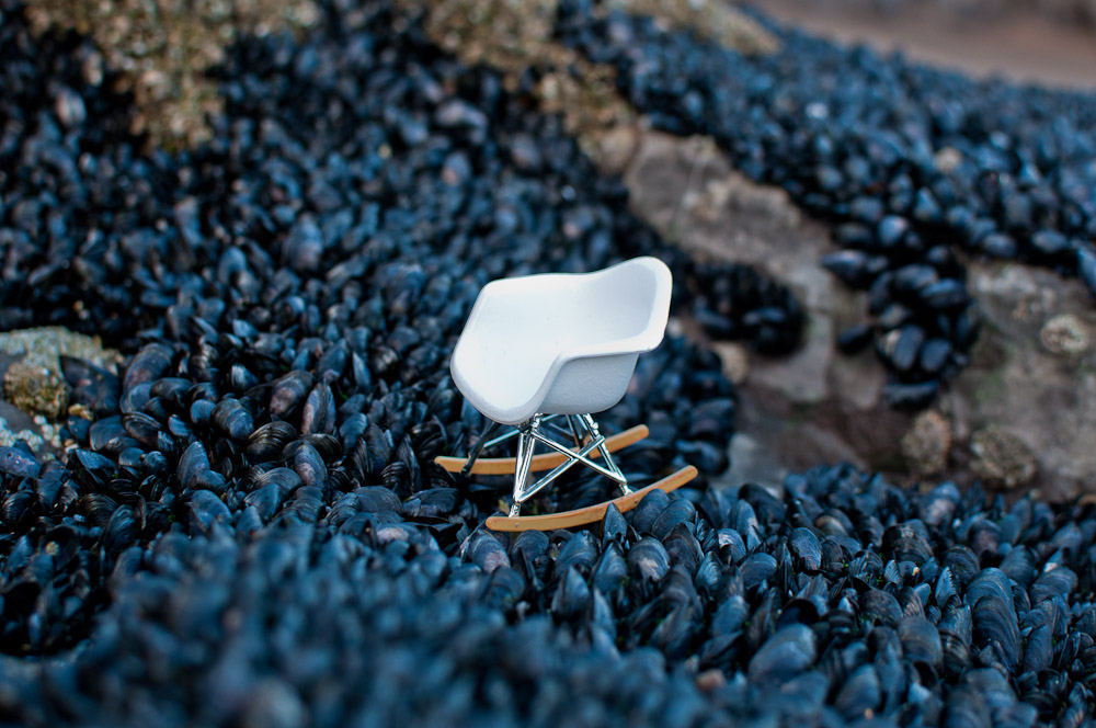 Small white Eames rocking RAR chair on seashells in Wales